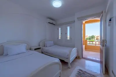 a bedroom with two beds and a balcony at Luxury Stays in Nubia El Gouna in Hurghada