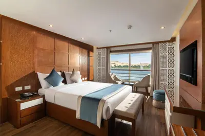 a bedroom with a large bed and a television at 4 nighhts luxury Nile cruise from Luxor to Aswan in Qena