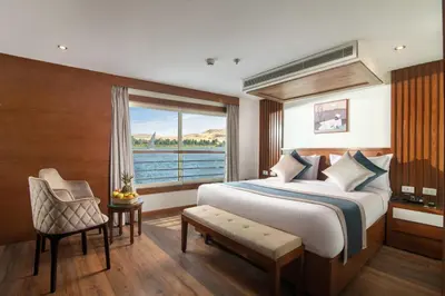 a bedroom with a large bed and a large window at 4 nighhts luxury Nile cruise from Luxor to Aswan in Qena