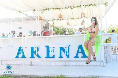 a woman in a bikini sitting on a sign on a boat at SELENA BAY Luxury Suite beach front hurghada Arena Bar & restaurant سويت فاخر سيلينا باى in Hurghada