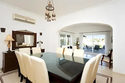 a dining room with a glass table and white chairs at Coral Blue 'An expansive spacious 4 bedroom villa in El Gouna' in Hurghada