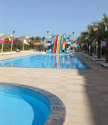 a large swimming pool with a water slide at فندق فنادير باي in Hurghada
