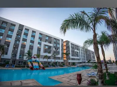 a large apartment building with a large pool with a large inflatable character at فندق فنادير باي in Hurghada