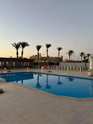 a large swimming pool with palm trees in the background at منتجع سكانديك الغردقة in Hurghada
