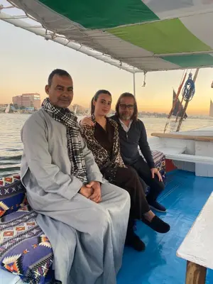 three people sitting on the back of a boat at king tut apartment in Luxor