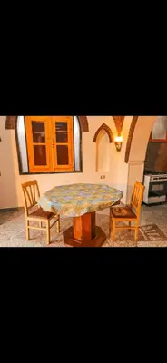 a dining room with a table and two chairs at Paradise Apartments in Al Aqālitah