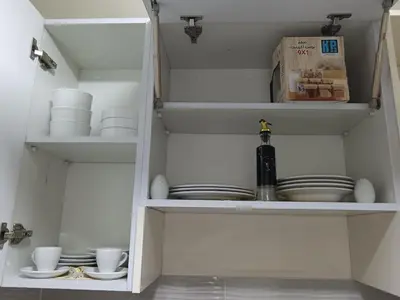 a white cabinet with plates and dishes in it at Hurghada Studio Tiba Golden Resort in Hurghada