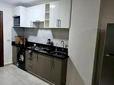 a kitchen with a sink and a washing machine at Hurghada Studio Tiba Golden Resort in Hurghada