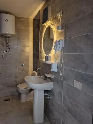 a bathroom with a sink and a toilet and a mirror at Hurghada Studio Tiba Golden Resort in Hurghada