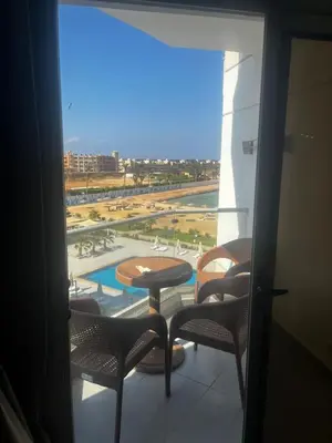 a balcony with chairs and a table and a pool at Scandic resort chalet sea view in Hurghada