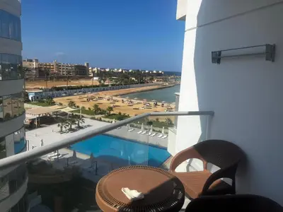 a balcony with a view of a pool and a beach at Scandic resort chalet sea view in Hurghada