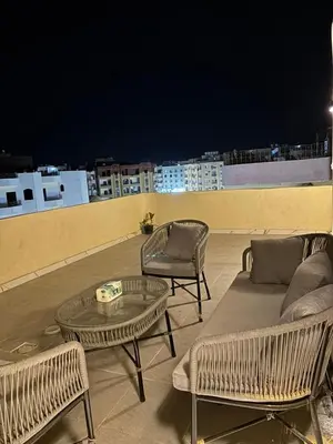 three chairs and a table on a rooftop at night at Top in Hurghada