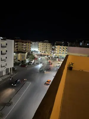 a city street at night with cars on the road at Sun Roof in Hurghada