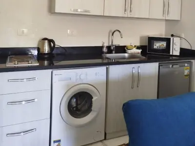 a kitchen with a washing machine and a sink at Cozy Chalet , Turtles , Side Sea View in Hurghada