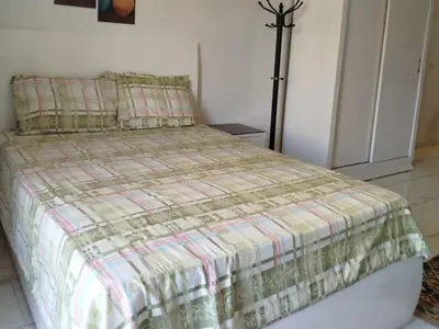 a bedroom with a bed with a green and white comforter at Cozy Chalet , Turtles , Side Sea View in Hurghada