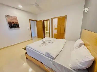a bedroom with a large bed with white sheets at Luxor in Al Karnak