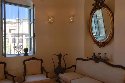 a living room with two chairs and a mirror at Habu Hotel in Al Aqālitah