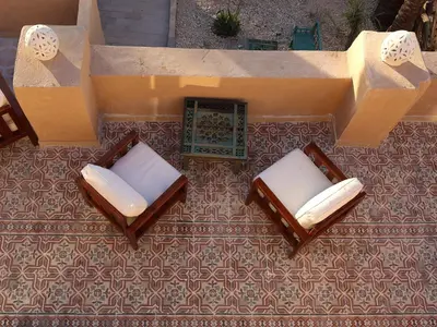 an overhead view of two chairs on a floor at Habu Hotel in Al Aqālitah