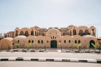 a large building with benches in front of it at Sultana Palace in ‘Ezbet Abu Ḥabashi