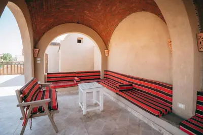 a row of red benches in a room with arches at Sultana Palace in ‘Ezbet Abu Ḥabashi