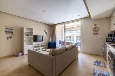 a living room with a couch and a tv at Mangroovy 1BR + Sofa bed • Pool & Beach Access in Hurghada