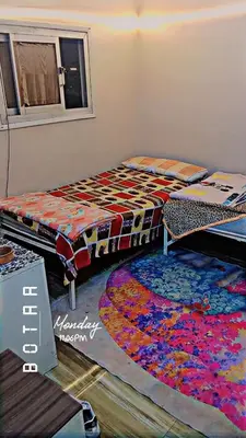 two beds in a room with a rug on the floor at البلدوزر وسط البلد شارع كسر الحجر الرئيسي in Aswan