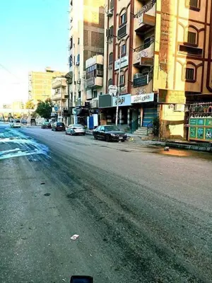 an empty city street with cars parked on the road at البلدوزر وسط البلد شارع كسر الحجر الرئيسي in Aswan