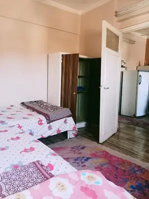 a room with two beds and an open door at البلدوزر وسط البلد شارع كسر الحجر الرئيسي in Aswan