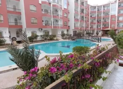an apartment complex with a swimming pool and flowers at Desert Pearl luxury apartment in Hurghada
