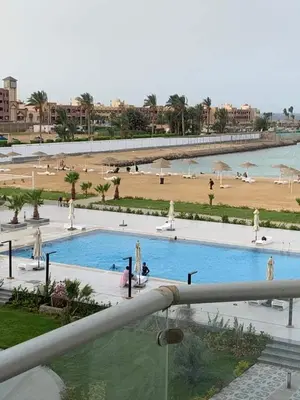 a view of a pool with people in a beach at شاليه خاص بمنتجع اسكاندك ريزورت in `Ezbet Bûgti