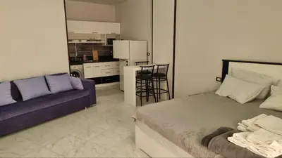 a bedroom with a bed and a purple couch at Sunny Studio Tiba View Red Sea in Hurghada