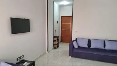 a living room with a purple couch and a flat screen tv at Sunny Studio Tiba View Red Sea in Hurghada