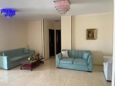 a living room with two blue couches and a table at Elhlal luxury apartment in Hurghada