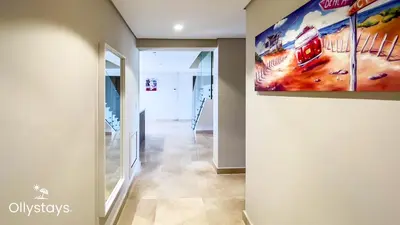 a hallway with a painting hanging on a wall at Ollystays Mangrovy Seaview Penthouse 3BR Beach & Pool access in Hurghada