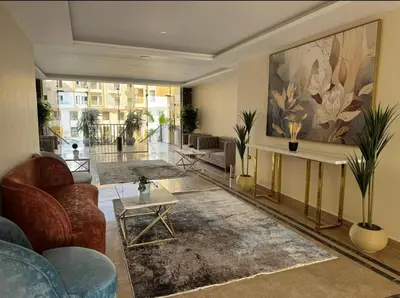 a living room with furniture and a large painting on the wall at Aqua Infinity in Hurghada