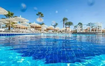 a large swimming pool with umbrellas and a resort at ميراج باي in Hurghada