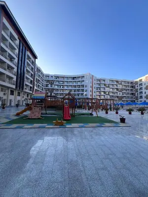 a playground in front of a large apartment building at Hurghada Tiba Golden Resort Apartment Strand Pool 22 in Hurghada