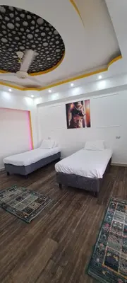two beds in a room with wooden floors at Egypt Soul hotel retreat in Luxor