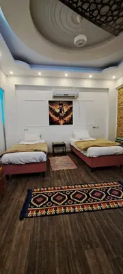 a bedroom with two beds and a rug at Egypt Soul hotel retreat in Luxor