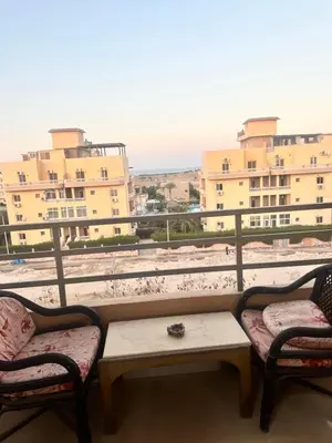 a balcony with two chairs and a table and some buildings at Bostan in Hurghada
