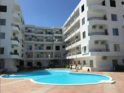 a swimming pool in front of a large apartment building at Hurghada Promenade Spacious 1-Bedroom Apartment in Makramia Compound in Hurghada