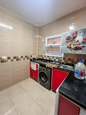 a kitchen with a stove and a washing machine at Hurghada Promenade Spacious 1-Bedroom Apartment in Makramia Compound in Hurghada