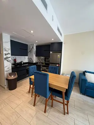 a kitchen with a wooden table and blue chairs at Casa bonita in Hurghada