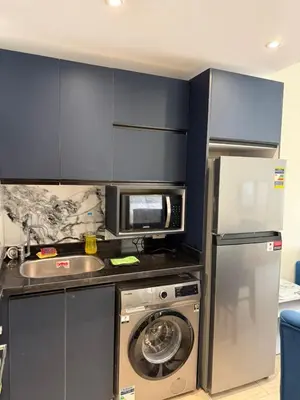 a kitchen with a washing machine and a microwave at Casa bonita in Hurghada