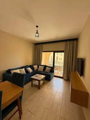 a living room with a blue couch and a table at Casa bonita in Hurghada