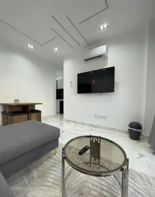 a living room with a couch and a tv on a wall at Endless Summer Apartment House W7 in Safaga