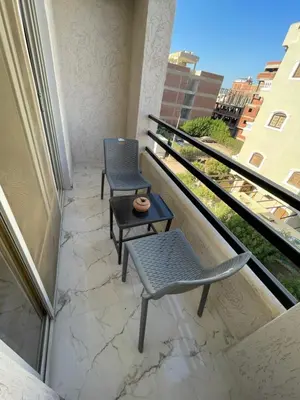 two chairs and a table on a balcony at Endless Summer Apartment House W7 in Safaga