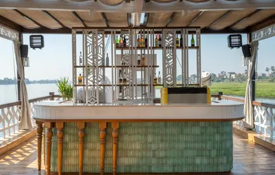a bar on a deck with a view of the water at HMC Zahra Dahabyia in Luxor