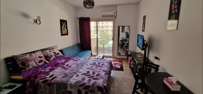 a bedroom with a purple bed and a window at Hurgada Florenza kamsen with pool view in Arabia area in Hurghada