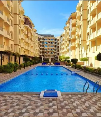 a large swimming pool in front of some apartment buildings at Hurgada Florenza kamsen with pool view in Arabia area in Hurghada